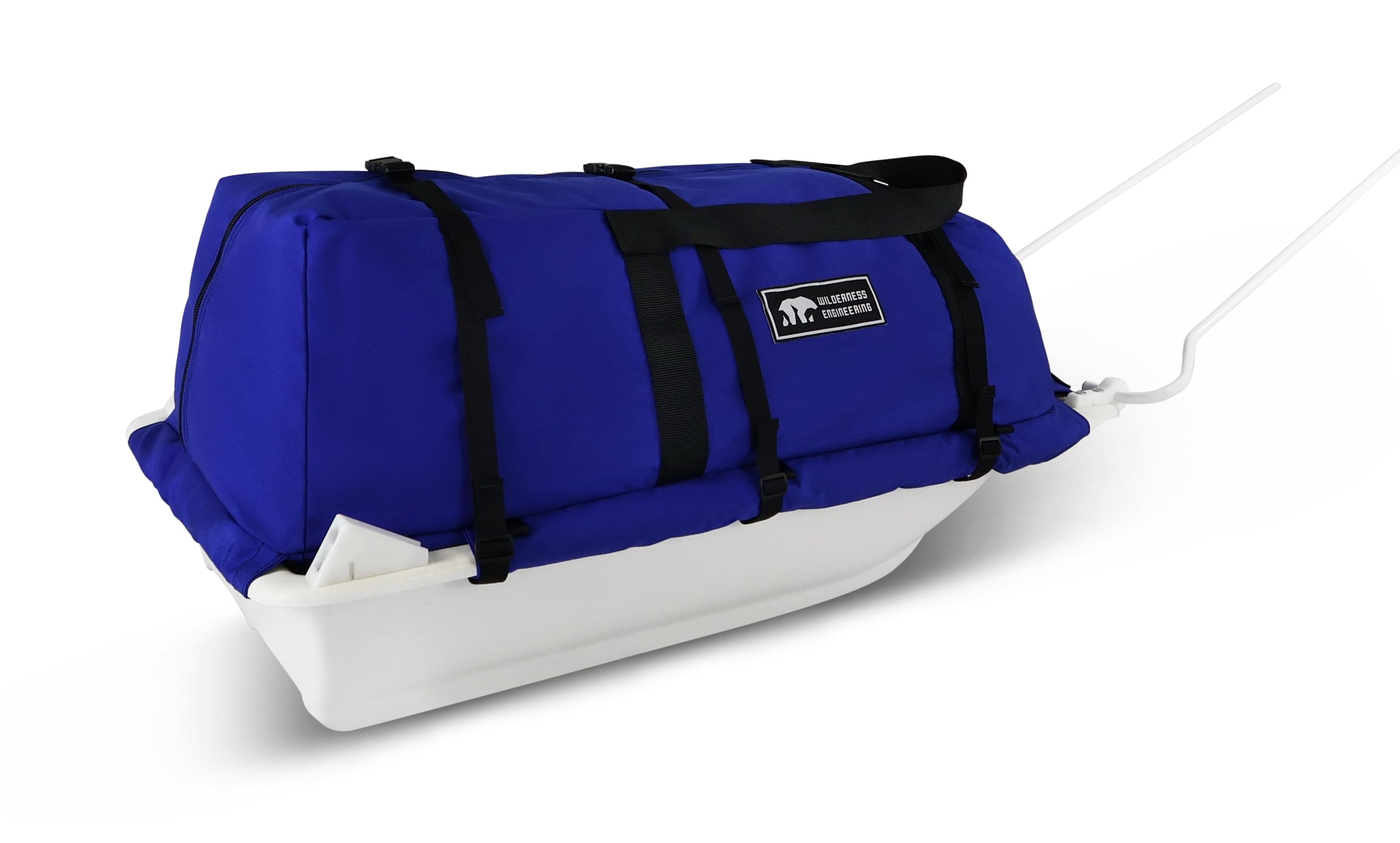 A Royal Blue snowmobile Sled Pulk cargo bag with black straps and a white plastic base, shown on a white studio background. With a tag labeled 'Wilderness Engineering'.