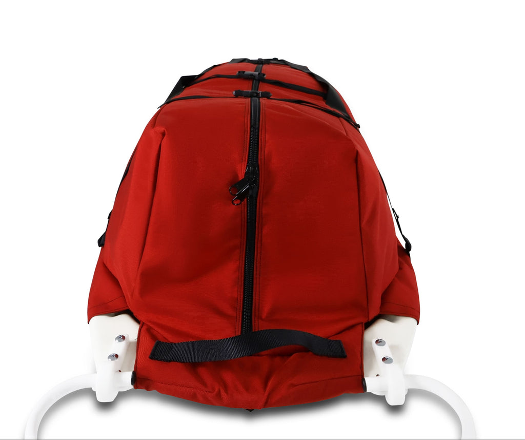 A Red snowmobile Sled Pulk cargo bag with black straps and a white plastic base, shown on a white studio background. With a tag labeled 'Wilderness Engineering'.